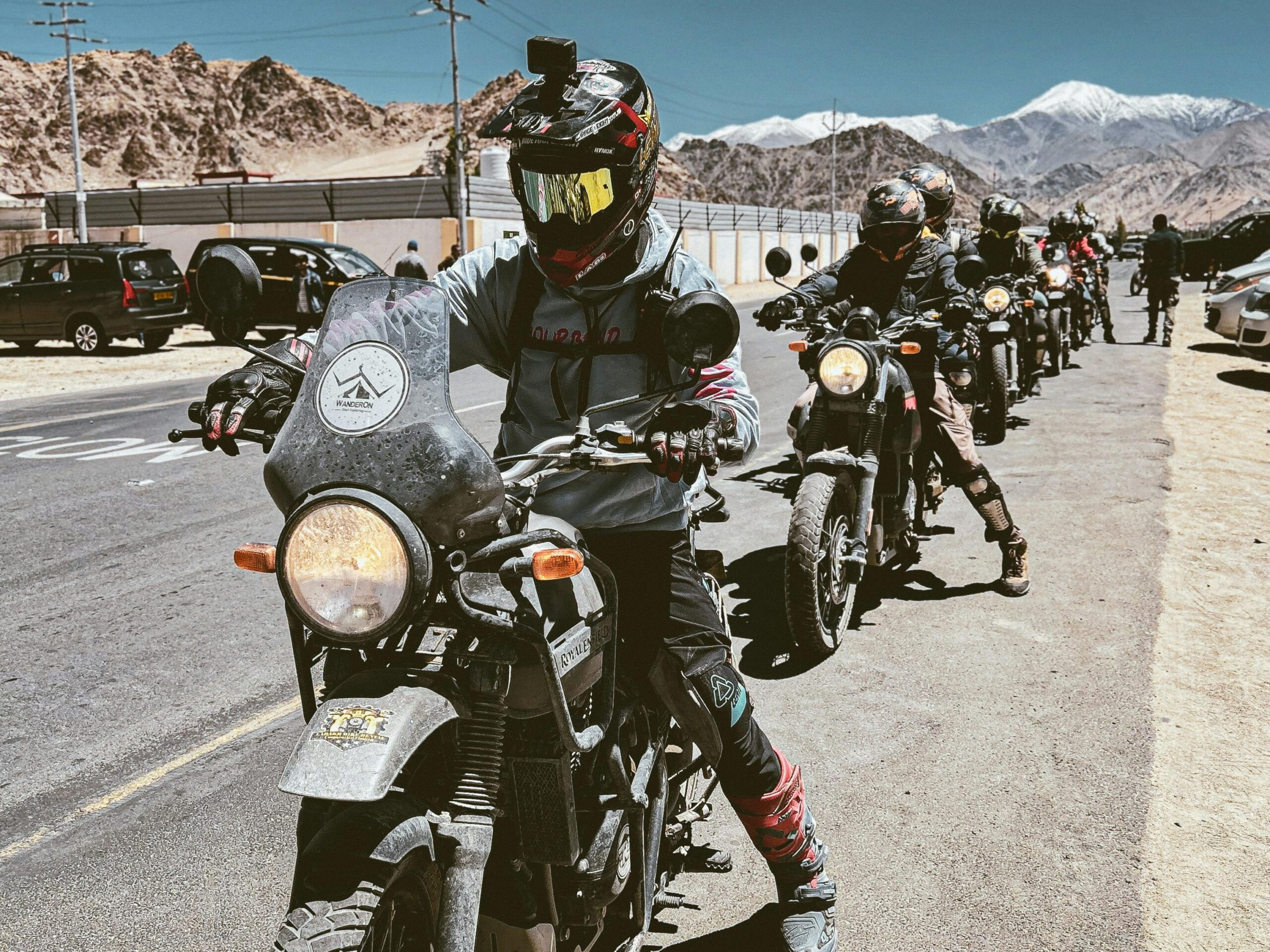Motorcyclists embarking on a scenic adventure ride in Leh, Ladakh with stunning mountain views.